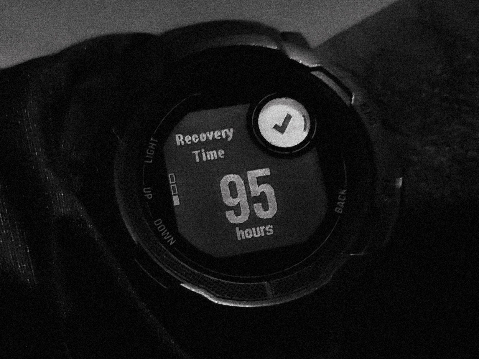 A training watch on a wrist, photographed in low light